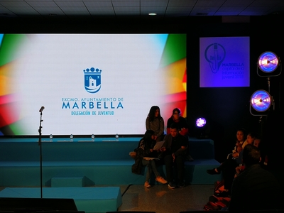 Escenario iluminado con el logotipo del Ayuntamiento de Marbella pero sin nadie subido a él
